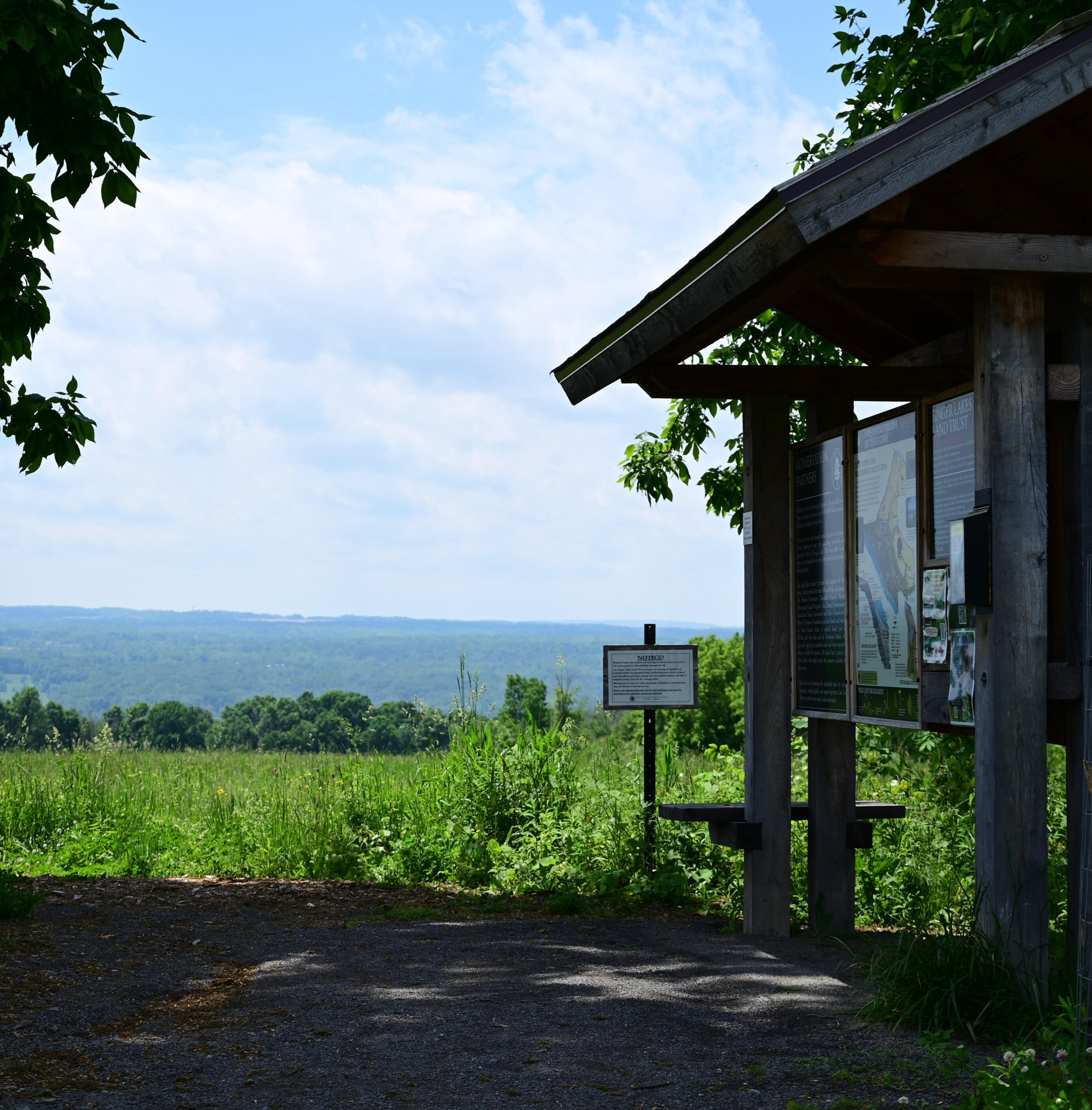 The Trailhead A shaded trail head over looks rolling meadows in the Finger Lakes of Upstate New York